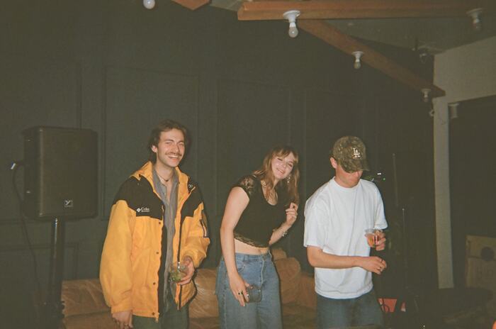 Three guests dancing beside a speaker
