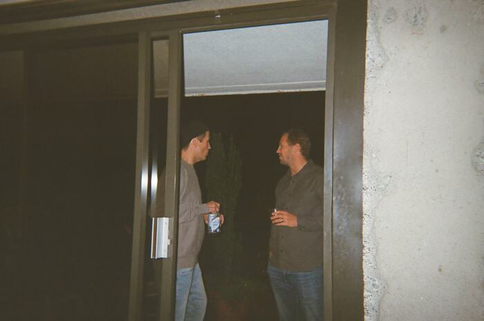 Two guests talking in the patio doorway