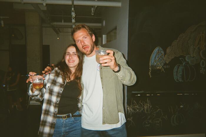Two guests posing with drinks, one raising his cup