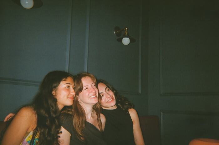 Three guests leaning their heads together and smiling
