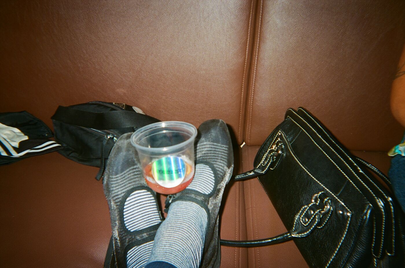 A cup with a holographic sticker balanced on a pair of striped socks