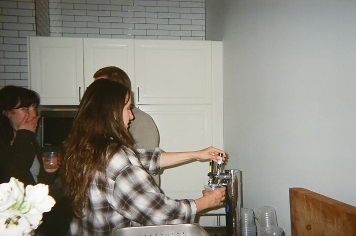 A guest in a plaid shirt pouring herself a drink from the taps