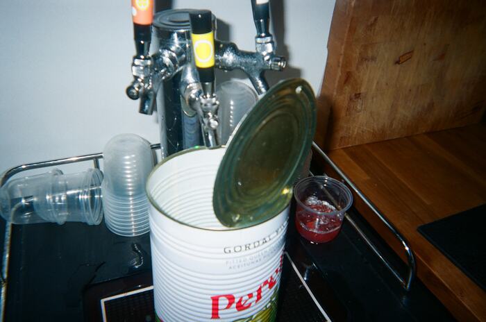 The tap tower with a catering tin of olives and a red drink beside it