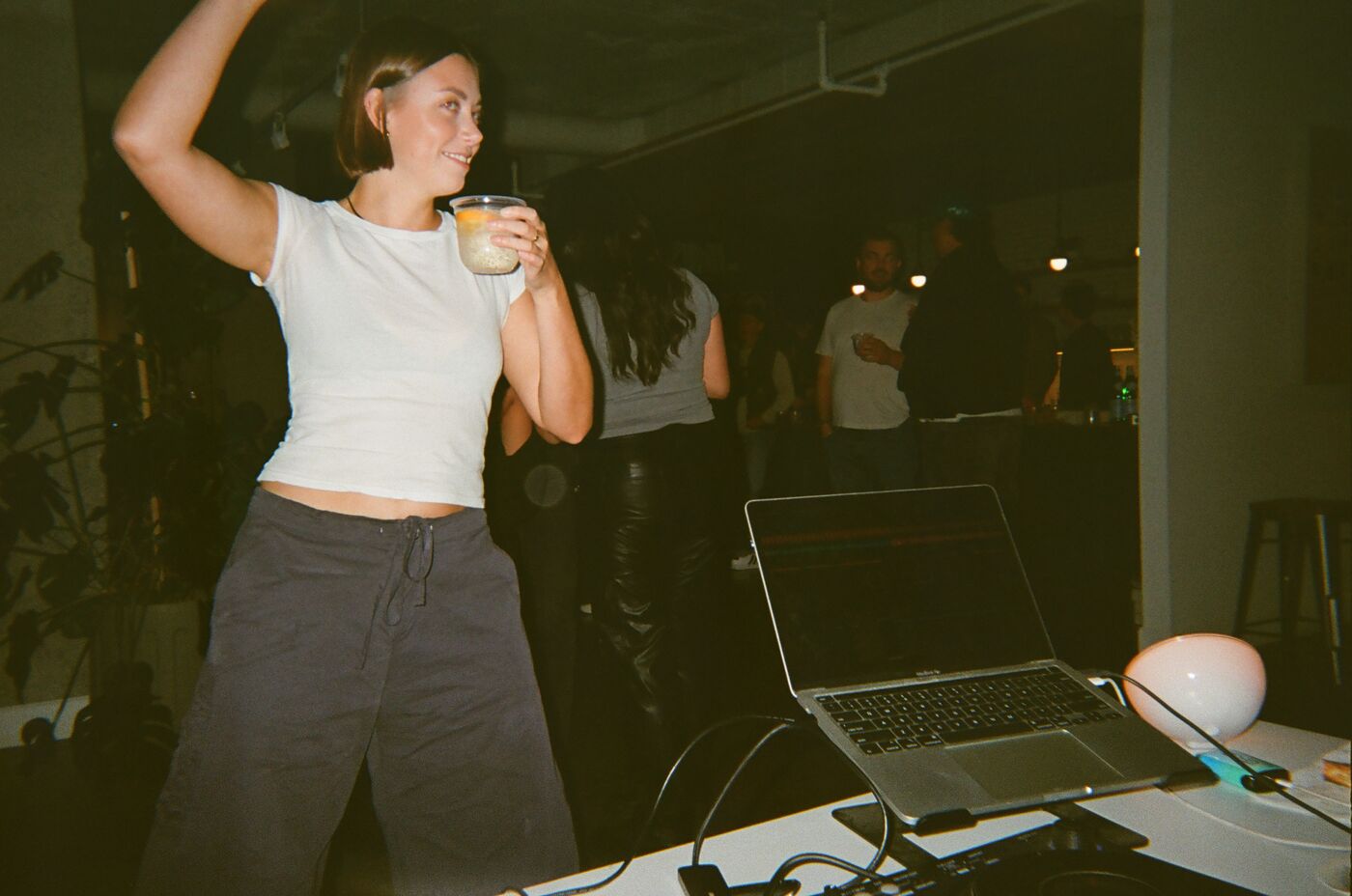 A guest dancing with one arm in the air and a drink in the other hand