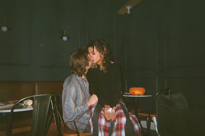 Two guests kissing at a corner table
