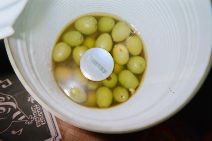 Looking down into a catering tin of green olives