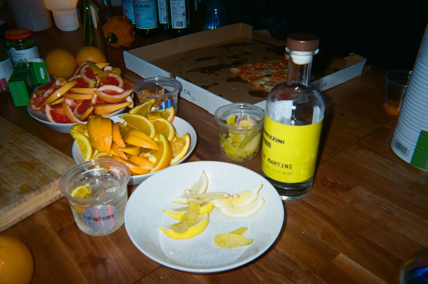 Plates of sliced orange, grapefruit and lemon beside the yellow-label Chamomile Martini bottle