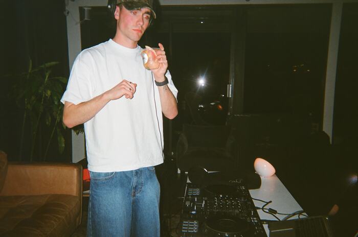 The DJ standing at the decks by the window