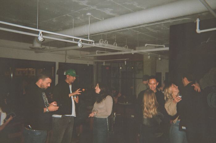Guests talking across the floor under the exposed ceiling