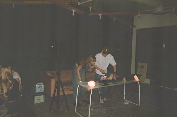 The DJ table from across the room, a camera tripod beside it