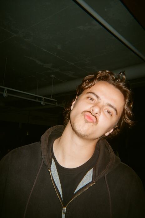 A guest leaning into frame sideways and pulling a face