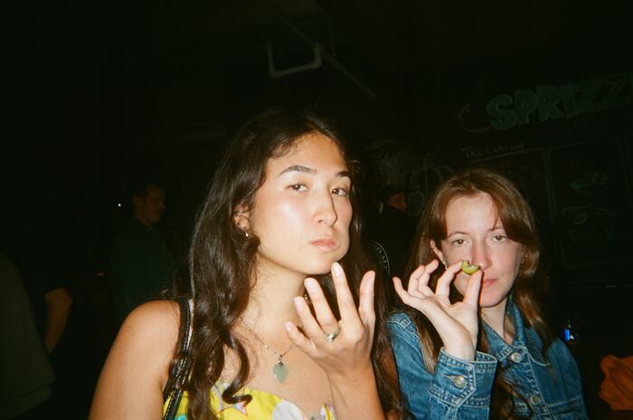 Two guests, one studying an olive held to her mouth