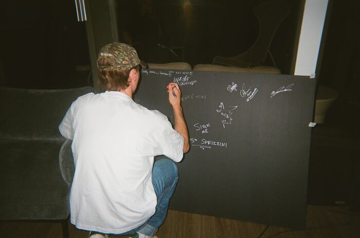 A guest crouching to sign the black board