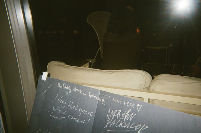 The signed black board propped against the patio couch