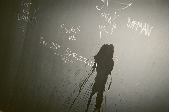 The signed board with a splash of drink running down it