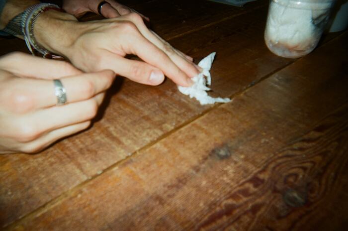 Hands dabbing the long table with a scrap of paper towel
