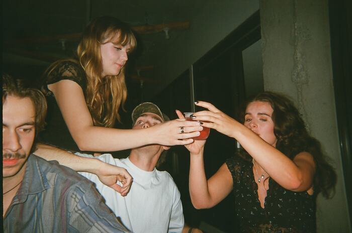 Two guests tipping a drink towards the DJ